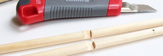 Cuttermesser mit Bambusstöcken auf weißem Untergrund